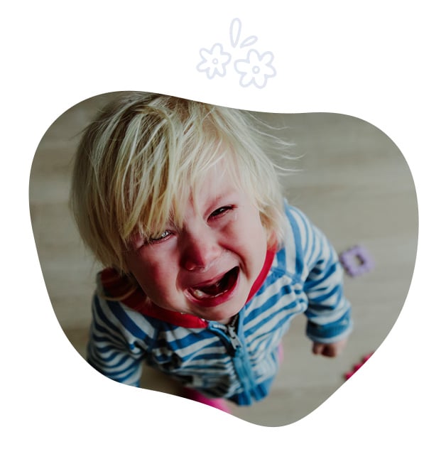 Petit enfant blond en larmes portant un pyjama rayé