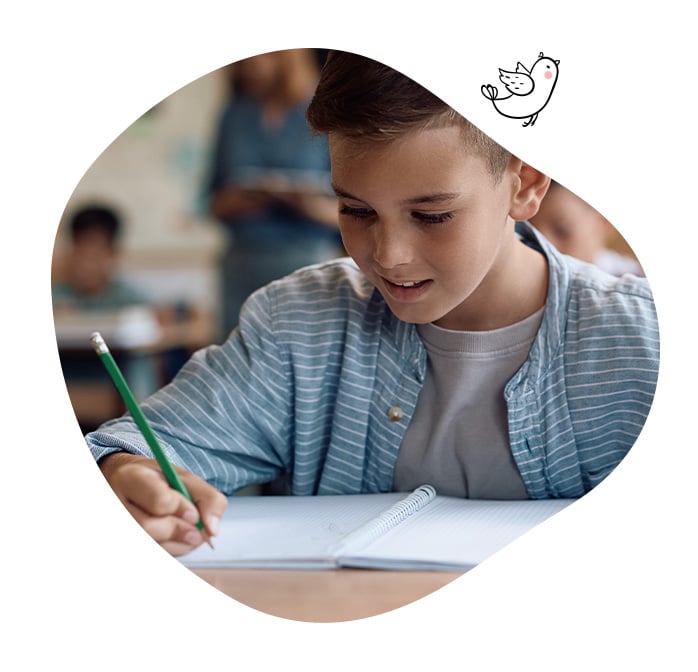 Écolier concentré en train d’écrire dans son cahier