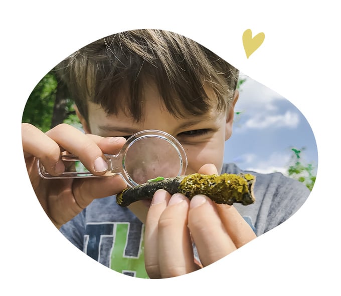 Enfant observant un morceau de bois avec une loupe